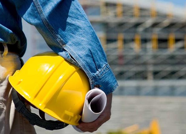 Person carrying hard hat and paper roll